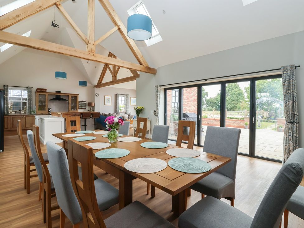 A dining room with a wooden table and chairs at Crossett Grange Driffield