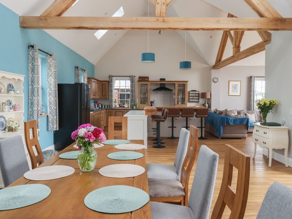 A dining room with a wooden table and kitchen in Crossett Grange Driffield