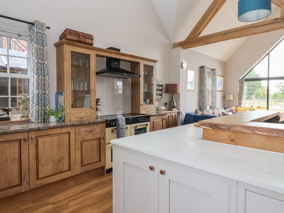 A kitchen with wooden cabinetry and a kitchen island at Crossett Grange in Driffield