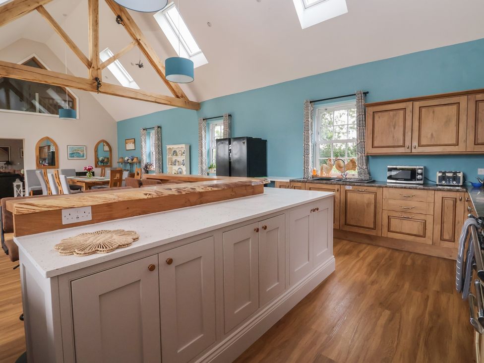 A kitchen with wooden cabinets and an island countertop at Crossett Grange in Driffield
