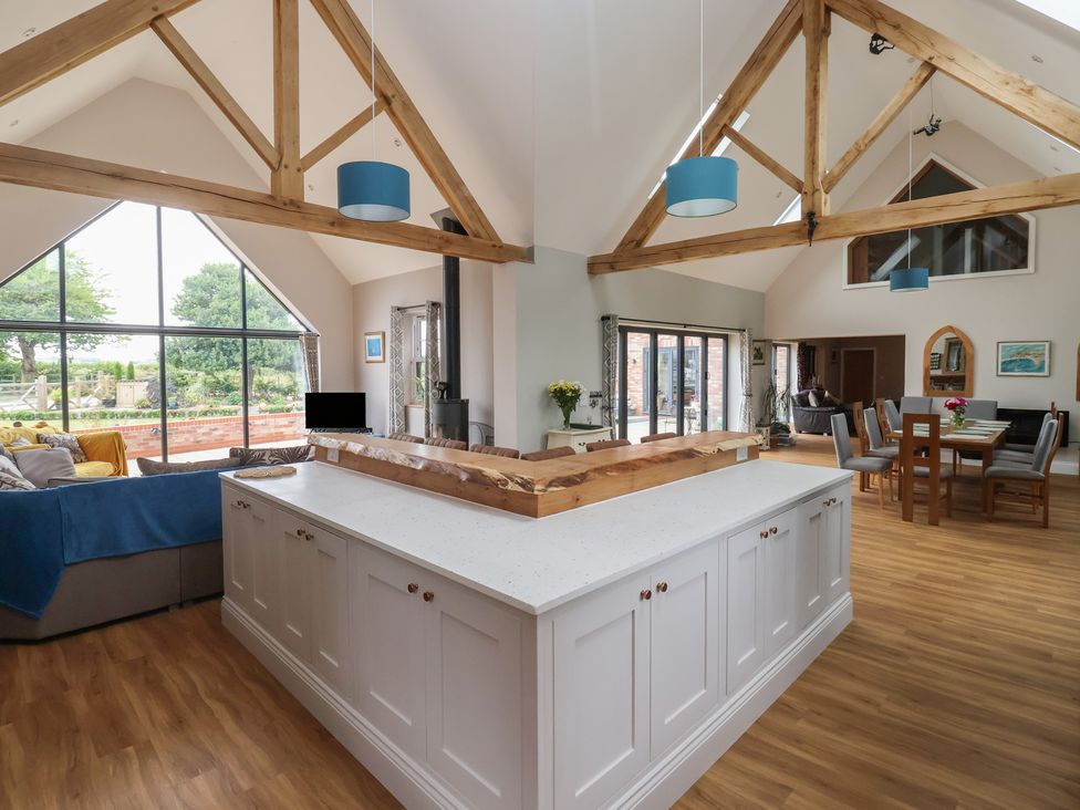 A kitchen with a dining area and large windows at Crossett Grange Driffield