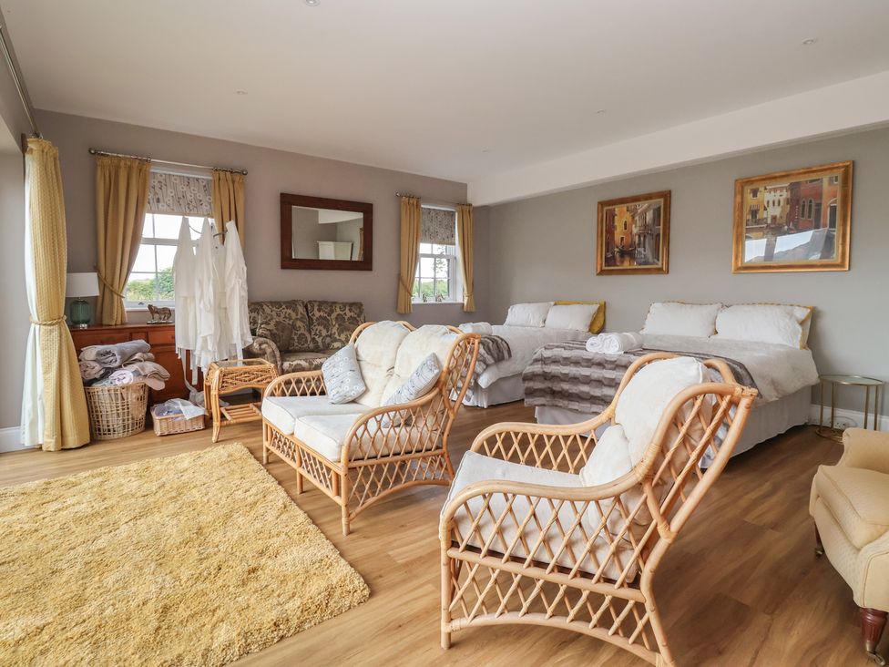 A bedroom with beds and seating area at Crossett Grange in Driffield