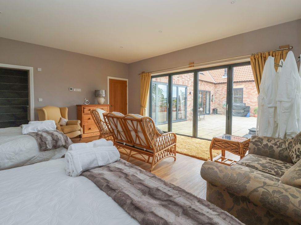 A bedroom with two beds and a living area at Crossett Grange in Driffield