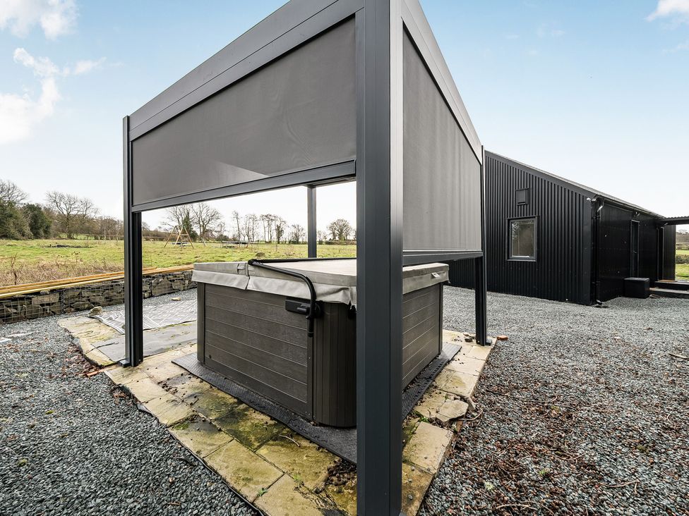 An outdoor area with a hot tub and canopy at Grove Cottage in Kington