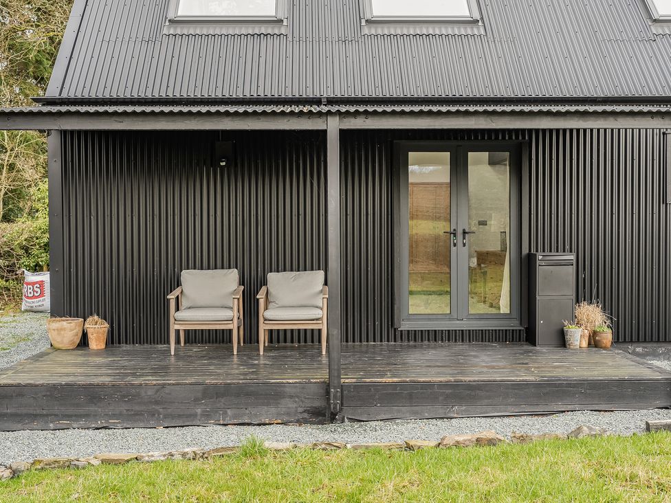 An outdoor area with chairs and a door at Grove Cottage Kington