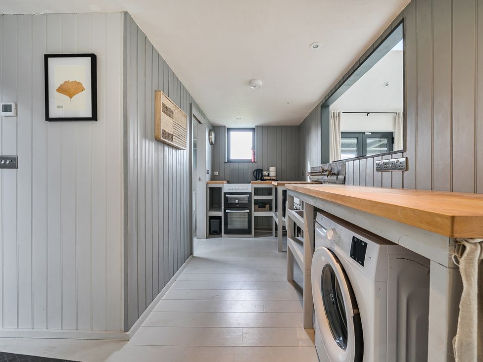 A utility room with a washing machine and a counter at Grove Cottage in Kington