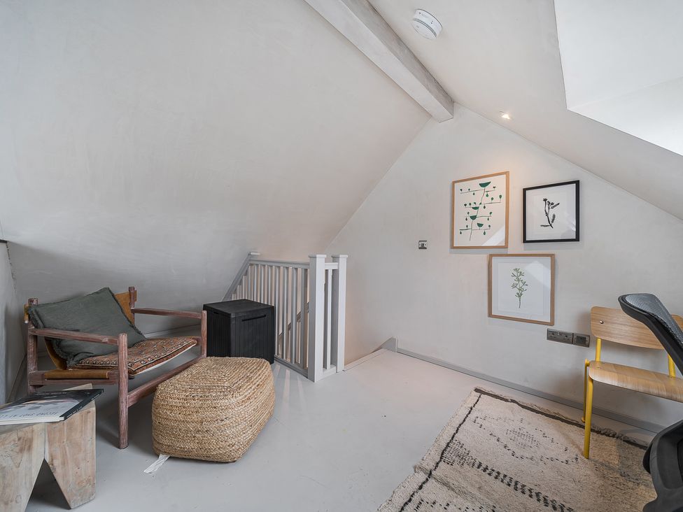 A study with a sofa and artwork on the walls at Grove Cottage in Kington