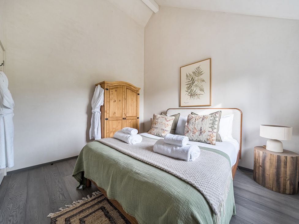 A bedroom featuring a bed, wardrobe, and lamp at Grove Cottage in Kington