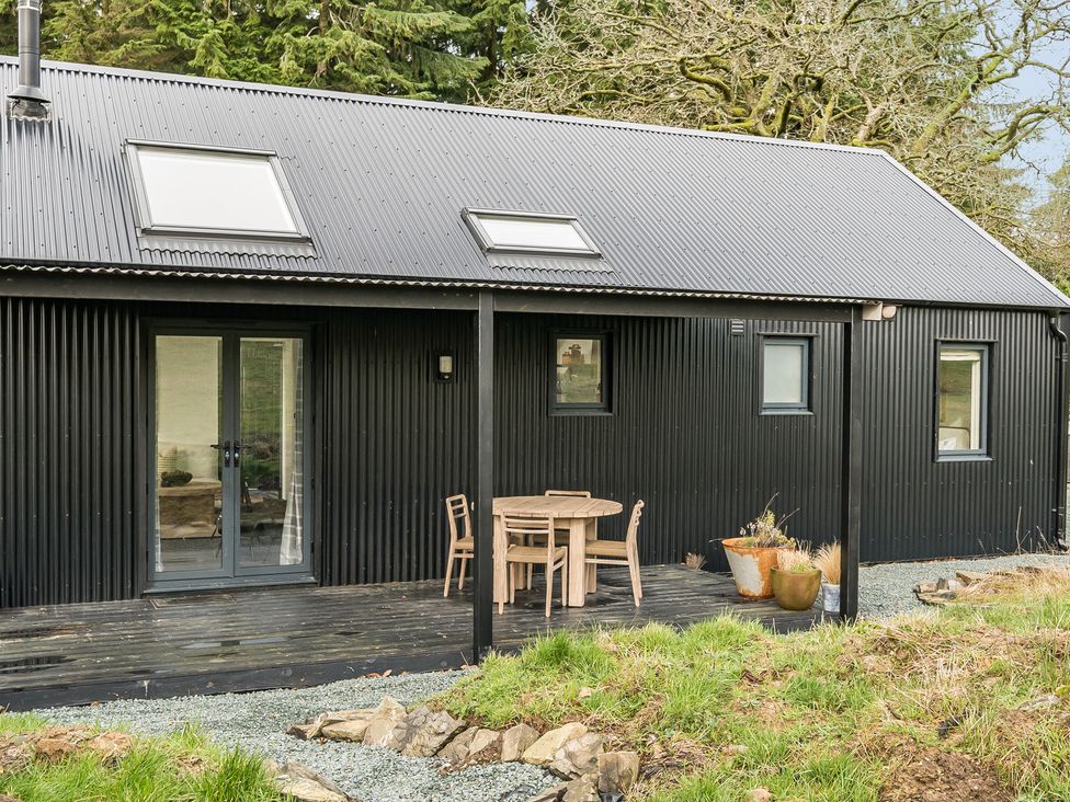 An outdoor seating area with a table and chairs at Grove Cottage in Kington