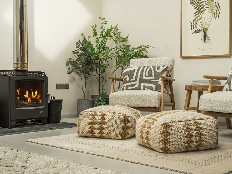 A living room with a fireplace and armchairs at Grove Cottage in Gladestry