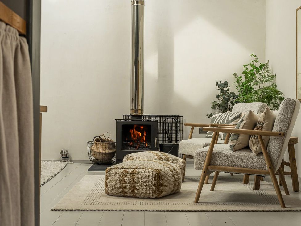 A living room with a sofa and fireplace at Grove Cottage in Gladestry