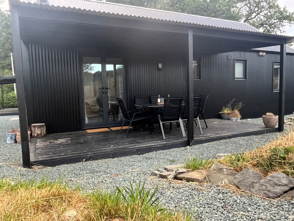 An outdoor seating area with a table and chairs at Grove Cottage in Gladestry