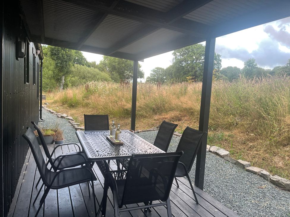 An outdoor seating area with a table and chairs at Grove Cottage in Gladestry