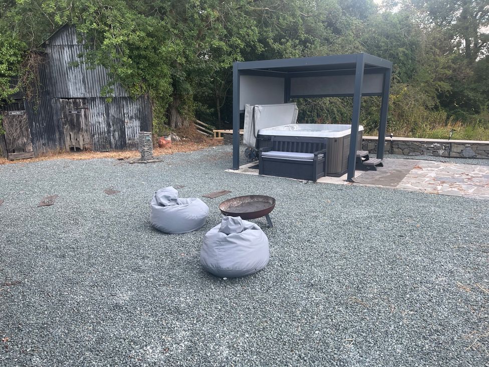An outdoor area with a hot tub and seating at Grove Cottage in Gladestry