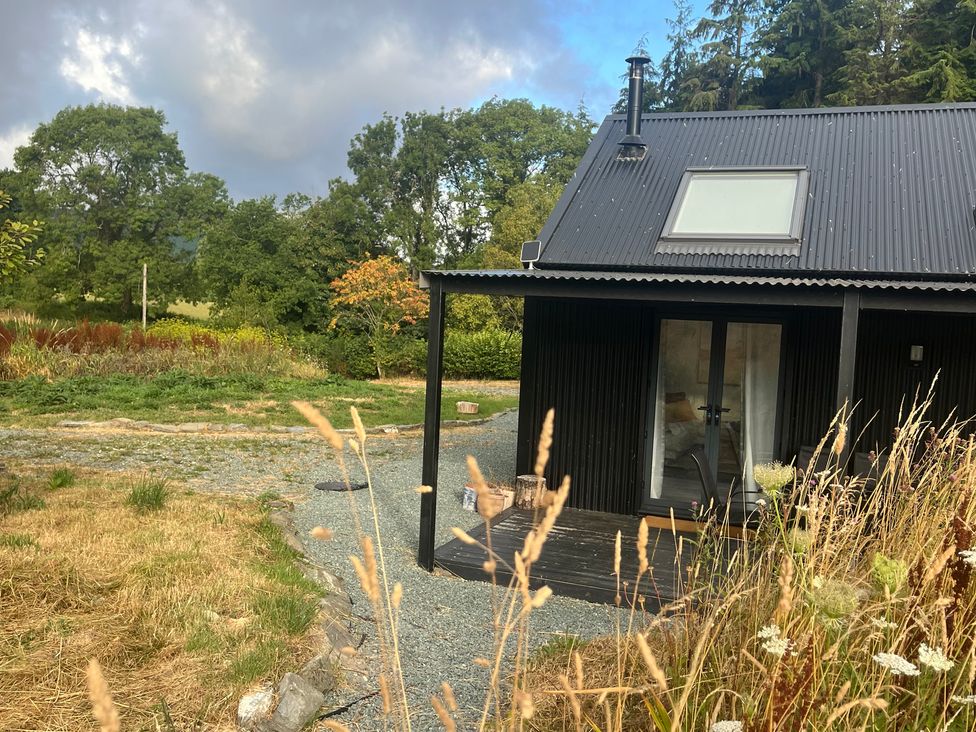 A cabin with a door and windows at Grove Cottage in Gladestry