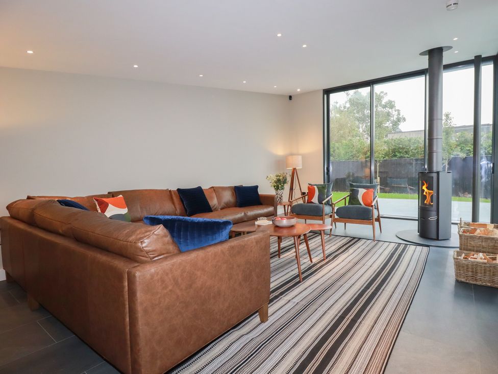 A living room with a sofa, chairs, and a fireplace at Harberton