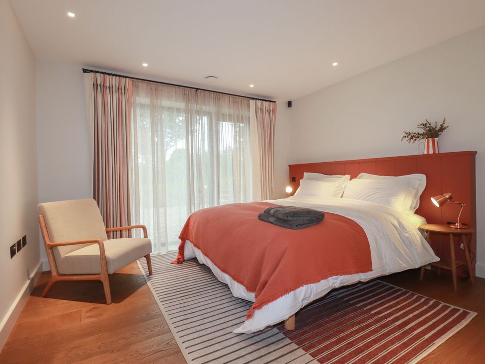 A bedroom with a bed and an armchair at Harberton