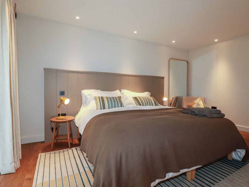 A bedroom with a bed and nightstand at Harberton