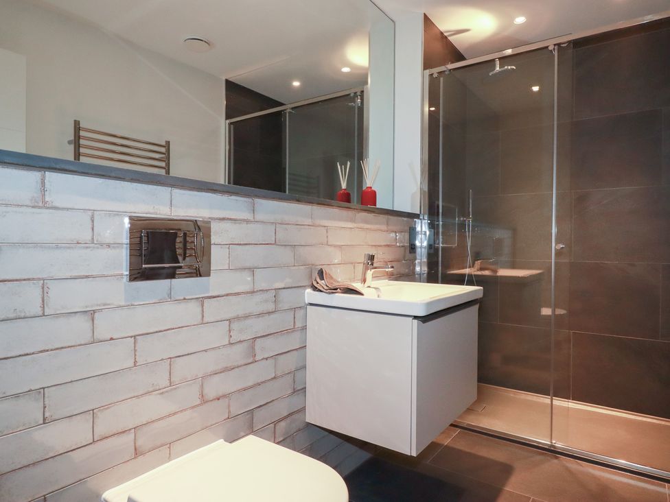 A bathroom with a sink, toilet, and shower at Harberton