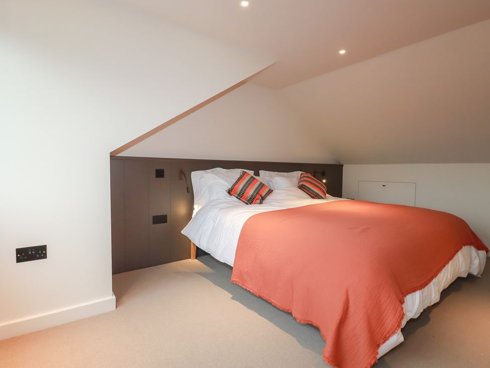 A bedroom with a bed and bedside lights at Harberton