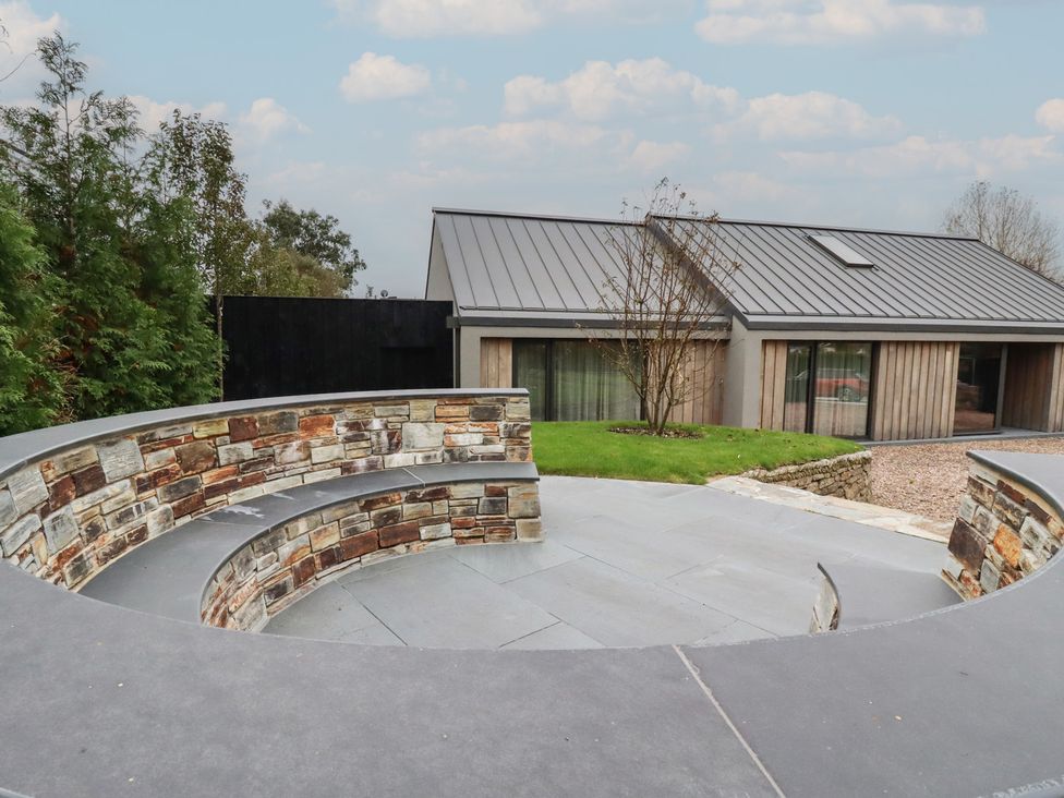 A garden view with a stone wall and a house in the background at Harberton