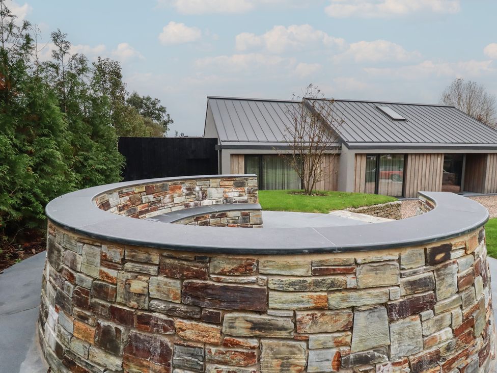 A stone wall and grass outside a modern house at Harberton