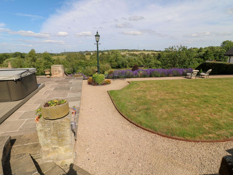 A garden with a hot tub and seating area at New Elms Farmhouse Melbourne, Derbyshire