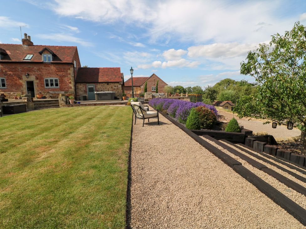 An outdoor area with a garden and seating at New Elms Farmhouse in Melbourne, Derbyshire