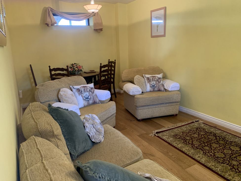 A living room with sofas and a table at Millers Cottage Seaville near Wigton