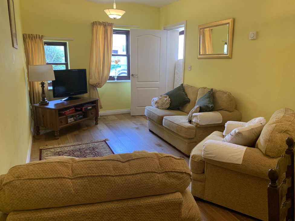 A living room with a sofa, a coffee table, and a television at Millers Cottage Seaville near Wigton