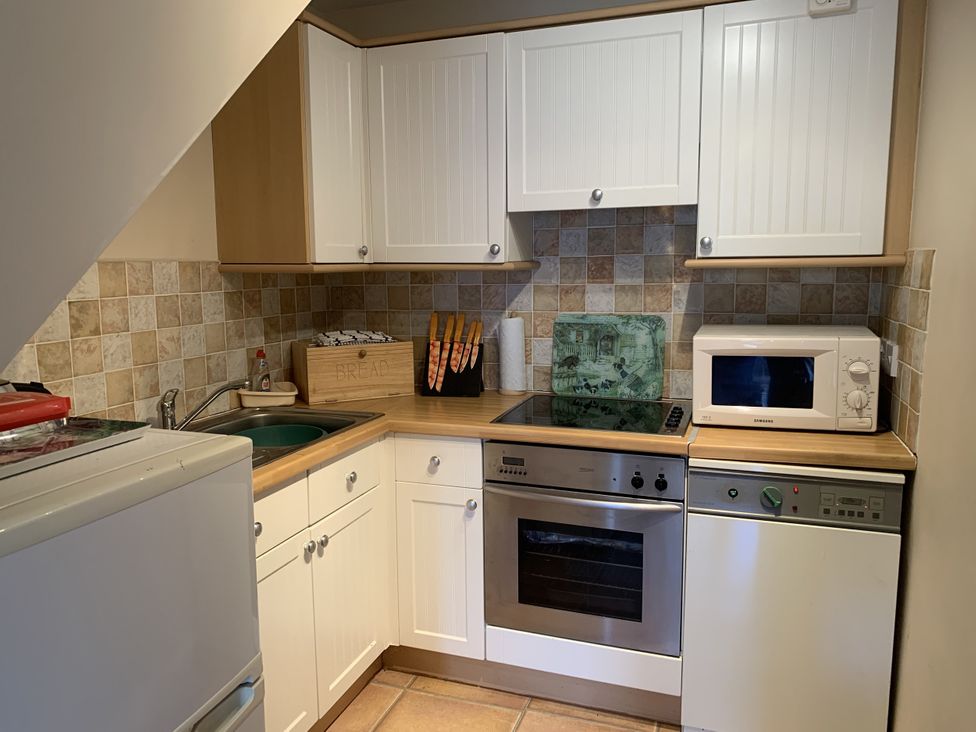 A kitchen with cabinets and appliances at Millers Cottage Seaville near Wigton