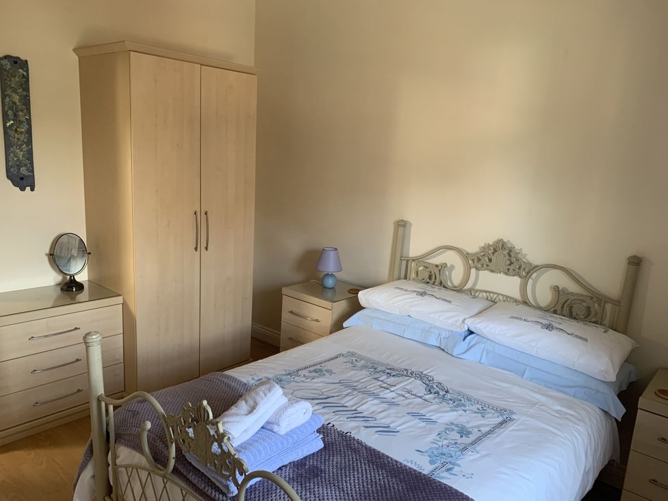 A bedroom with a bed and wardrobe at Millers Cottage Seaville near Wigton