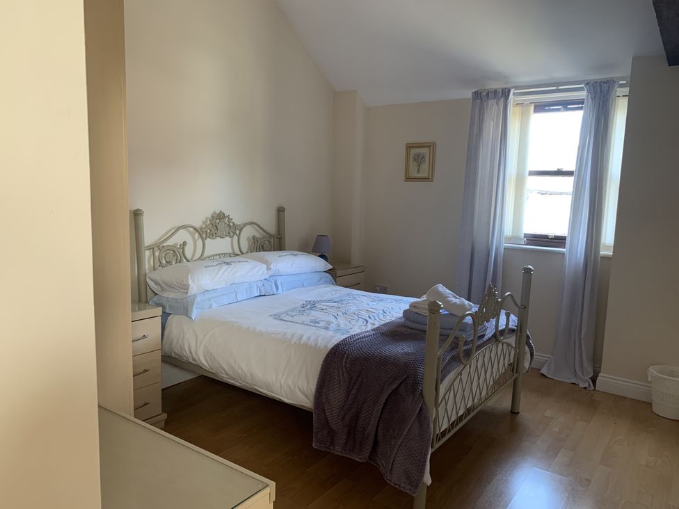A bedroom with a bed and window at Millers Cottage in Seaville near Wigton