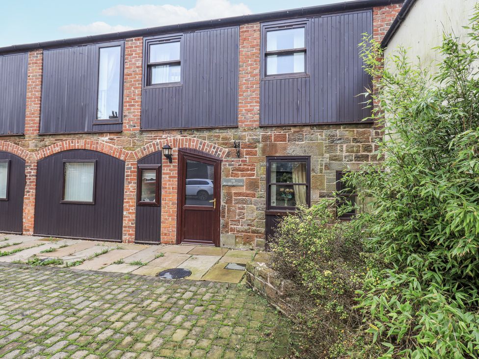 An outdoor view of a building with doors and windows at Millers Cottage Seaville near Wigton