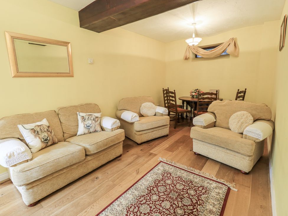 A living room with sofas and a table at Millers Cottage in Seaville near Wigton