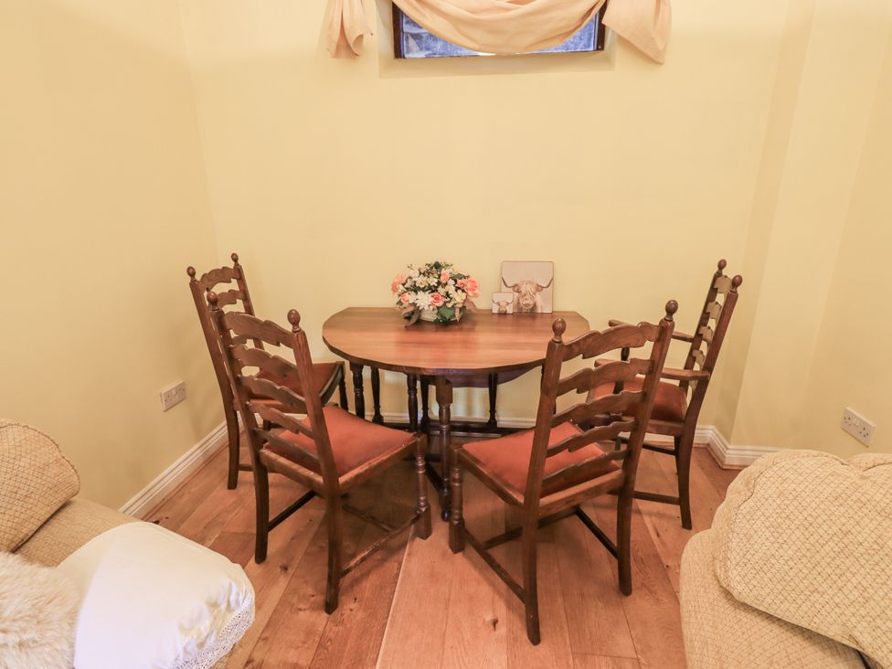 A dining area with a table and four chairs at Millers Cottage Seaville near Wigton