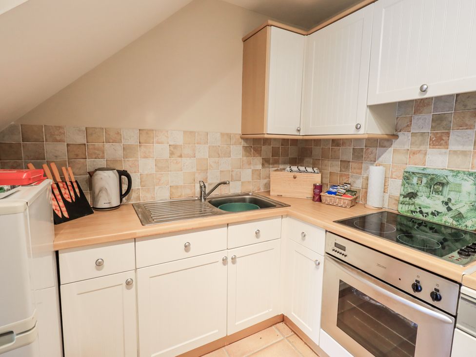 A kitchen with sink and stove at Millers Cottage Seaville near Wigton