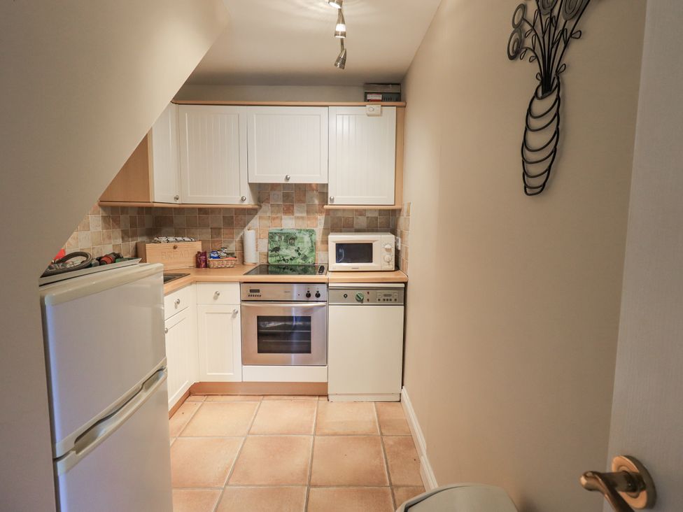 A kitchen with appliances and cabinets at Millers Cottage in Seaville near Wigton