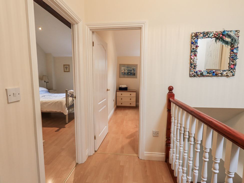 A corridor leading to a bedroom and staircase at Millers Cottage in Seaville near Wigton