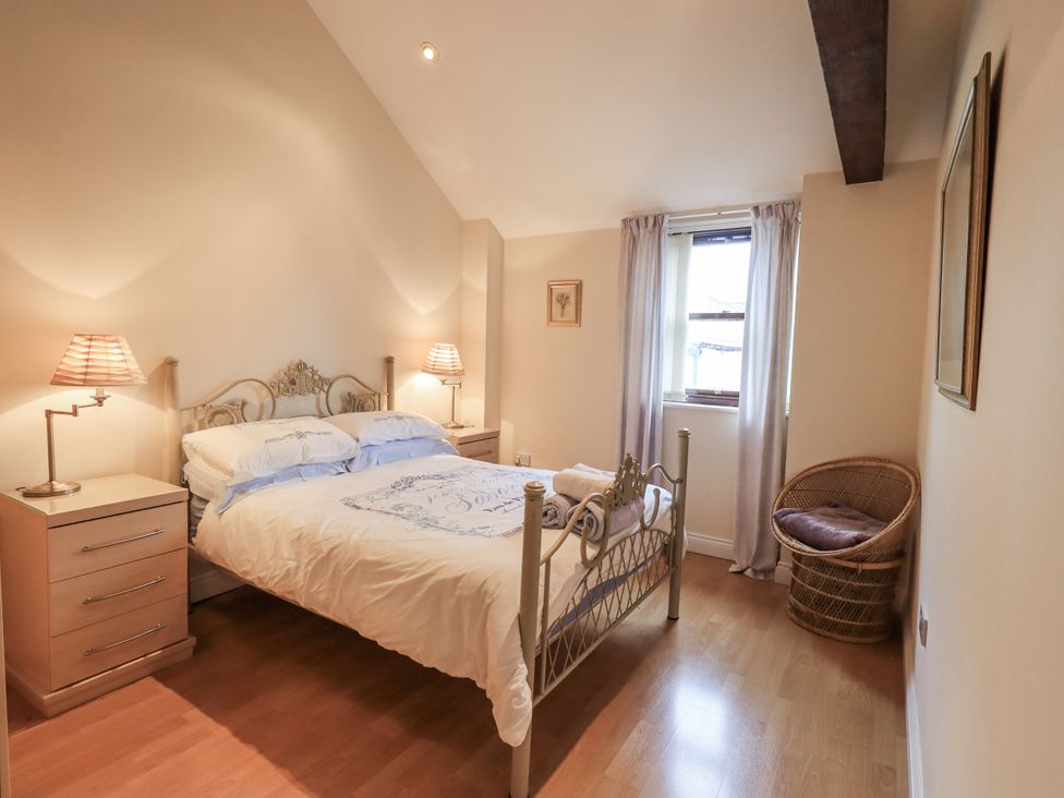 A bedroom with a bed and nightstand at Millers Cottage Seaville near Wigton