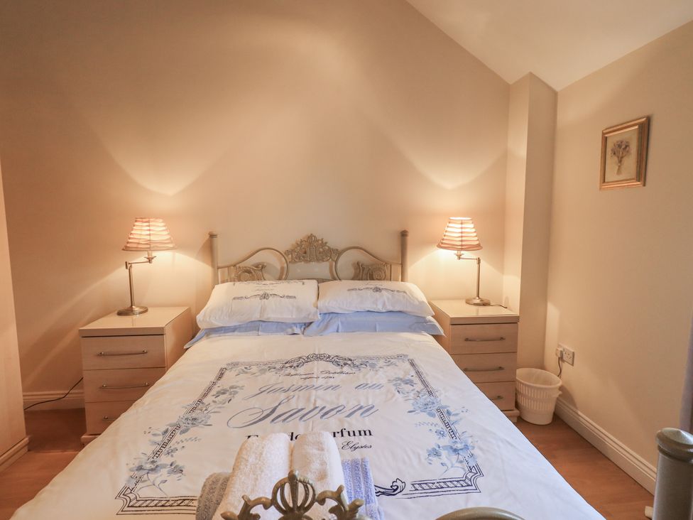 A bedroom with a bed and bedside tables at Millers Cottage Seaville near Wigton