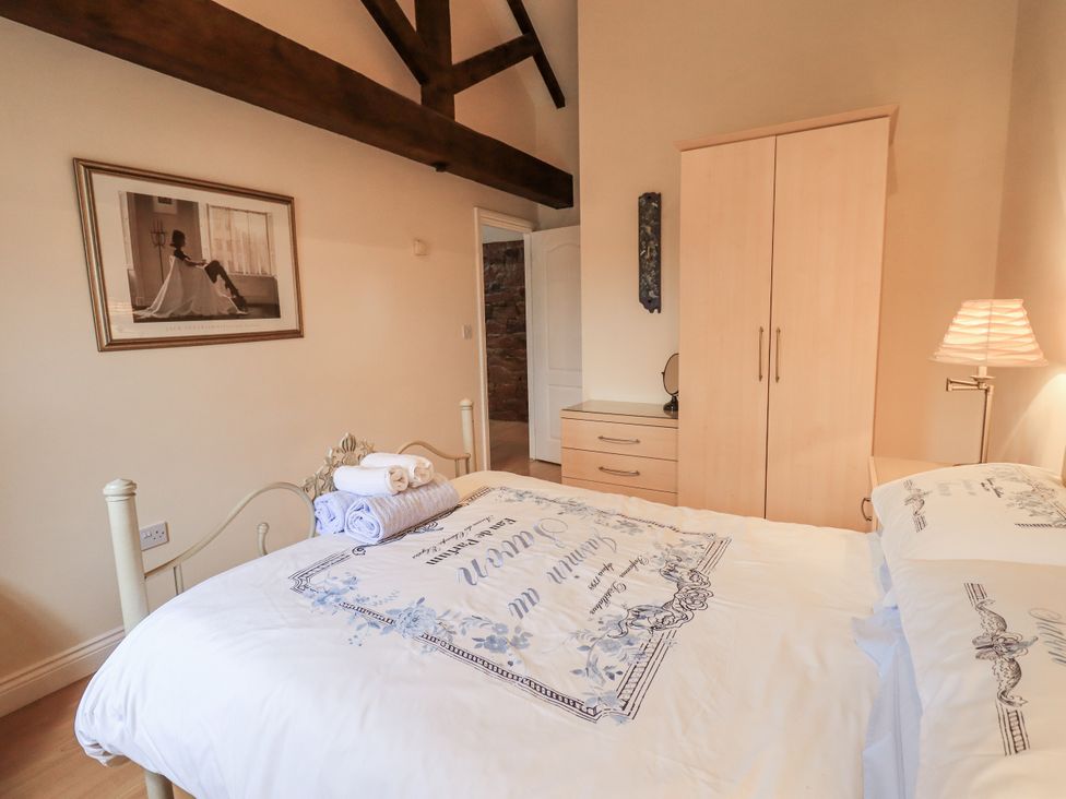A bedroom with a bed and wardrobe at Millers Cottage Seaville near Wigton