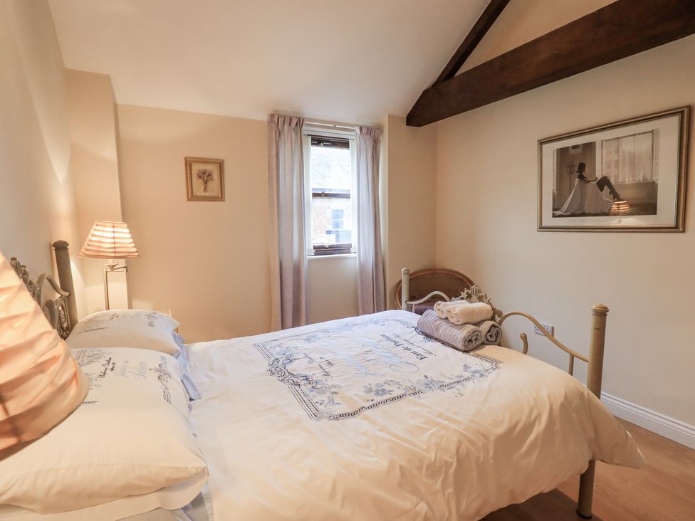 A bedroom with a bed and window at Millers Cottage Seaville near Wigton