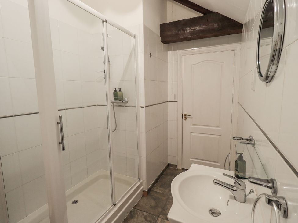 A bathroom with a shower and sink at Millers Cottage Seaville near Wigton