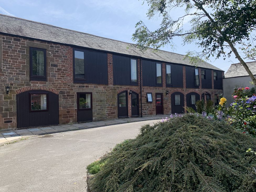 A building with multiple windows and a pathway at The Hayloft near Wigton