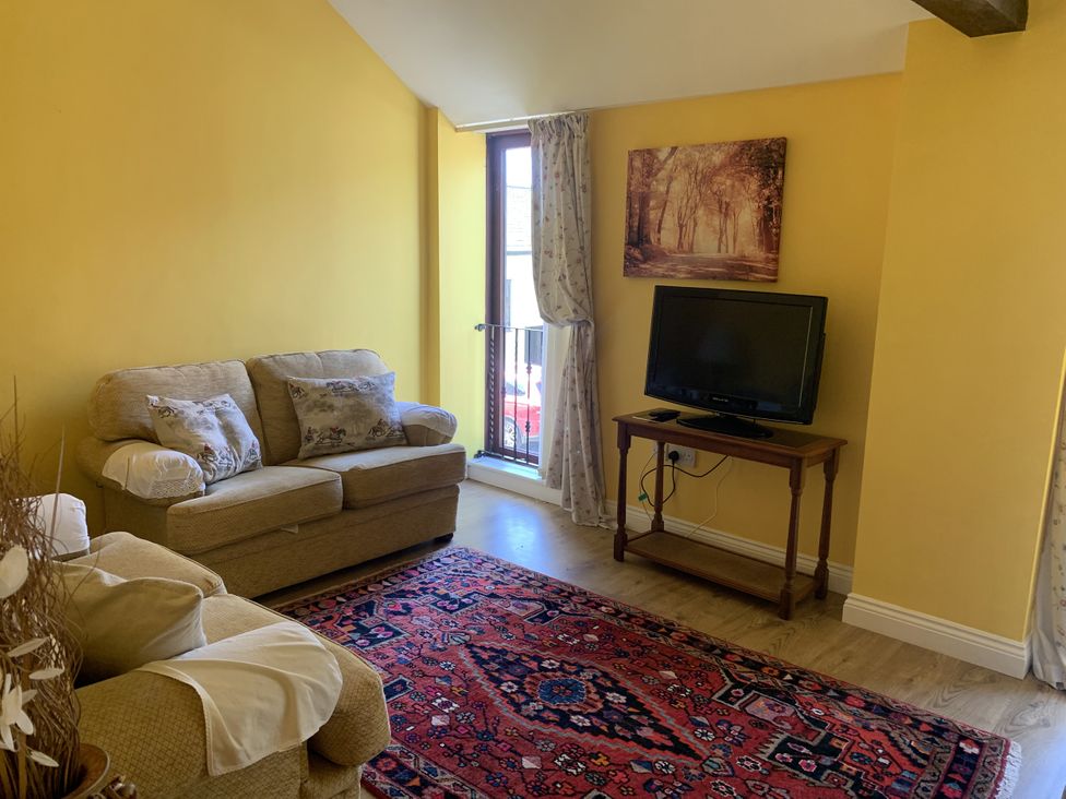 A living room with a sofa and television at The Hayloft near Wigton