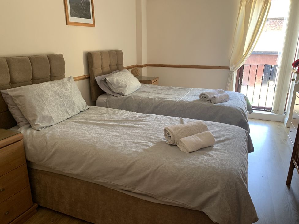A bedroom with two single beds and a window at The Hayloft near Wigton