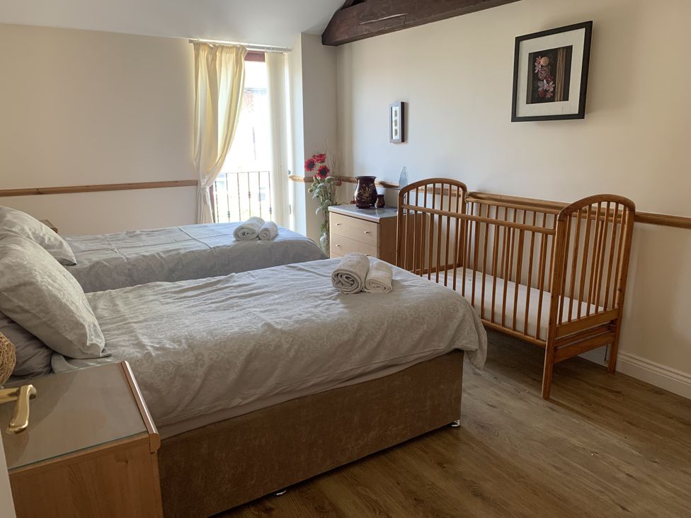 A bedroom with two single beds and a cot at The Hayloft near Wigton