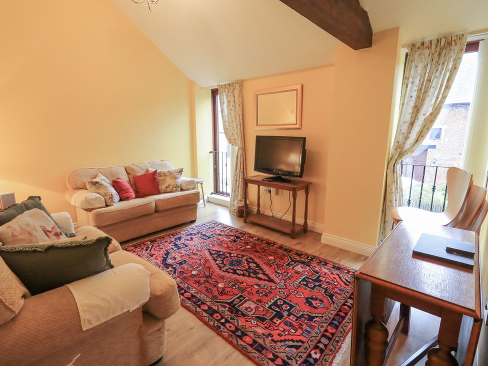 A living room with a sofa and television at The Hayloft near Wigton