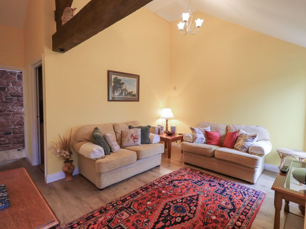A living room with sofas and a lamp at The Hayloft near Wigton